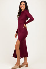 woman wearing a burgundy long sleeve maxi dress with a side slit and beige block heels