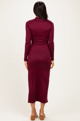 woman wearing a burgundy long sleeve fitted dress that falls to mid-calf, viewed from the back