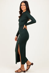 woman wearing a dark green long sleeve maxi dress with a side slit and brown sandals