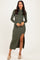 woman wearing an olive green long sleeve maxi dress with a side slit and a fitted silhouette