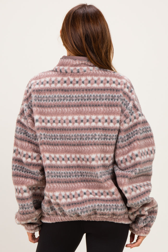 woman wearing a patterned oversized fleece pullover in shades of pink and gray, shown from the back