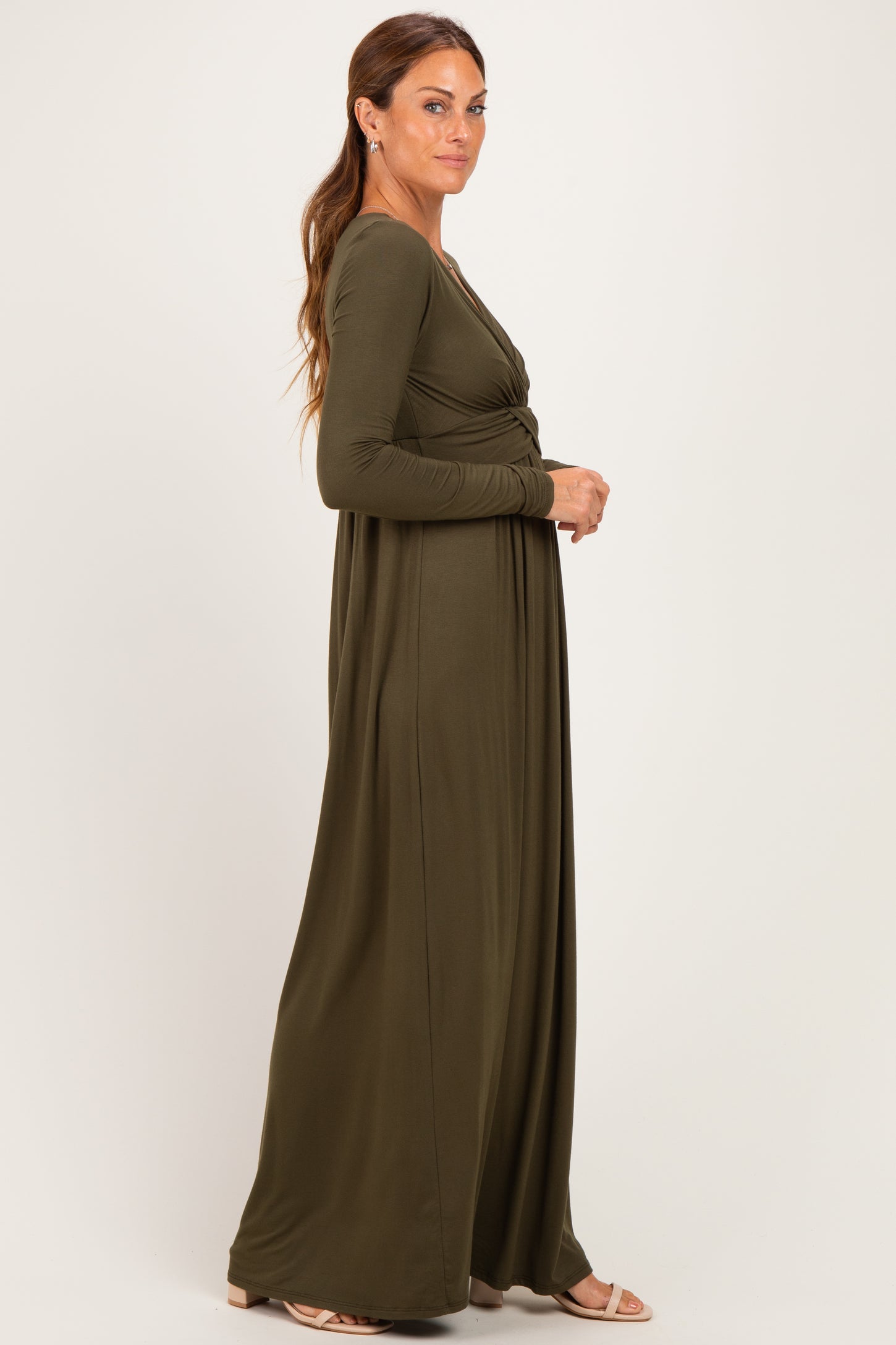 woman wearing a long sleeve olive green maxi dress with a twist front detail