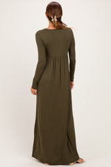 woman wearing a long olive green maxi dress with a fitted bodice and flowing skirt, seen from the back