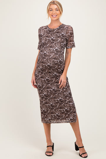 woman wearing a brown leopard print maternity dress with short sleeves and a visible baby bump