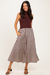 woman wearing a maroon sleeveless top and a striped midi skirt with pockets