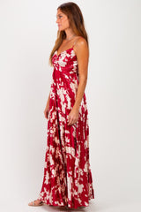 woman wearing a red floral maxi dress with a ruched bodice and spaghetti straps
