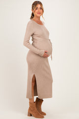 woman wearing a beige ribbed maternity dress with a side slit and tied waist, showcasing her baby bump