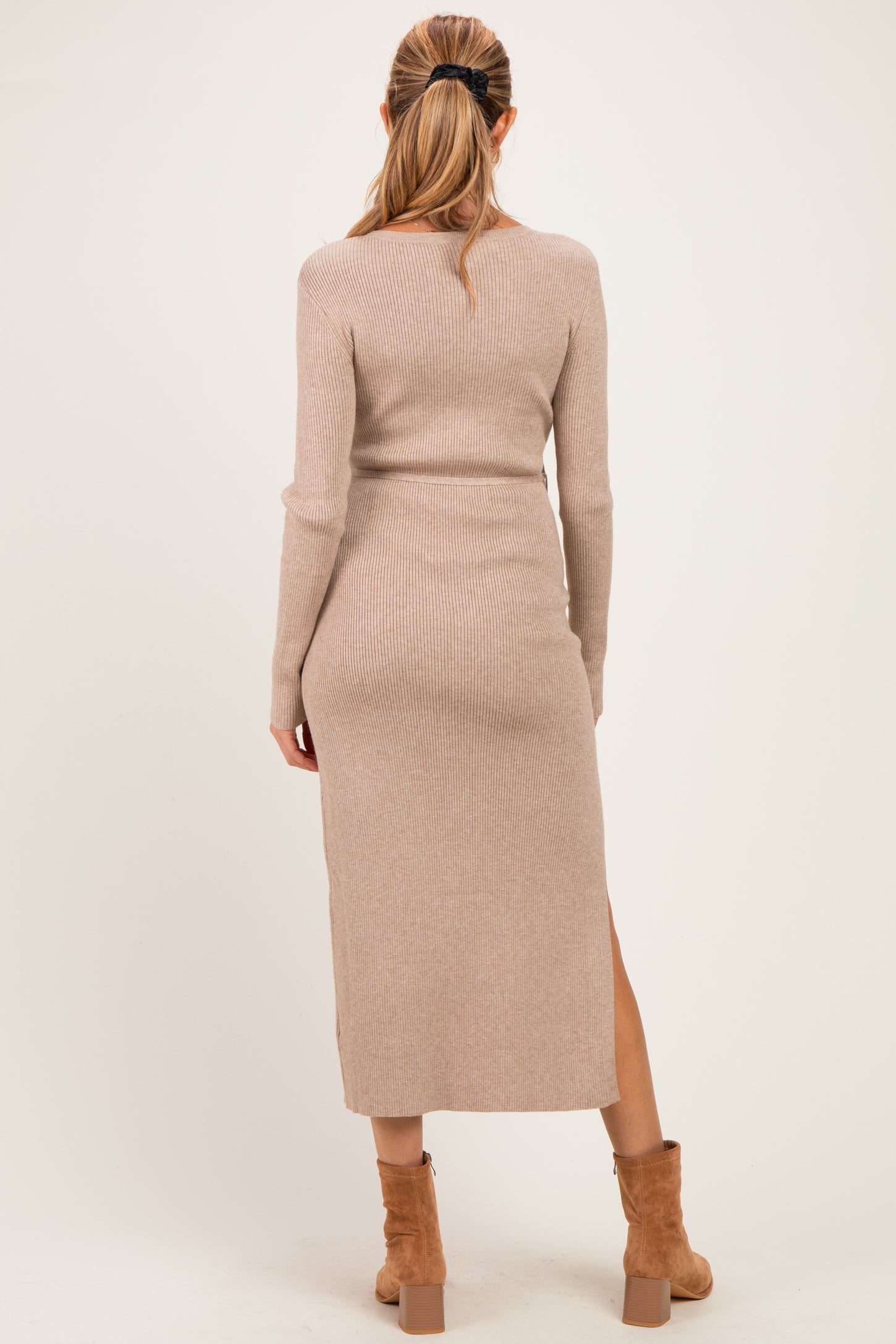 woman wearing a light beige ribbed long sleeve maternity dress with a thigh-high slit, shown from the back