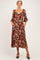 woman wearing a floral print maternity midi dress with three-quarter sleeves and pockets, showcasing her baby bump