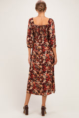woman wearing a floral print maternity dress with three-quarter sleeves and a square neckline, showing a baby bump