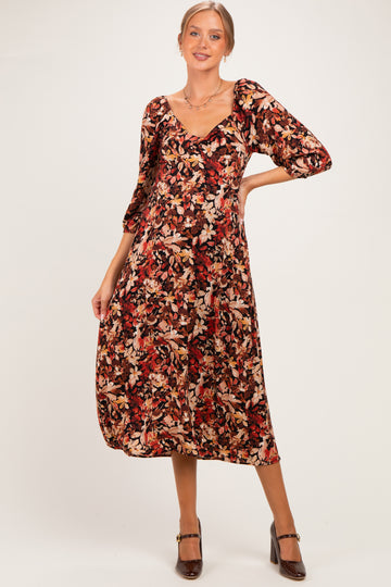 woman wearing a floral print maternity dress with three-quarter sleeves and a v-neckline, showing her baby bump