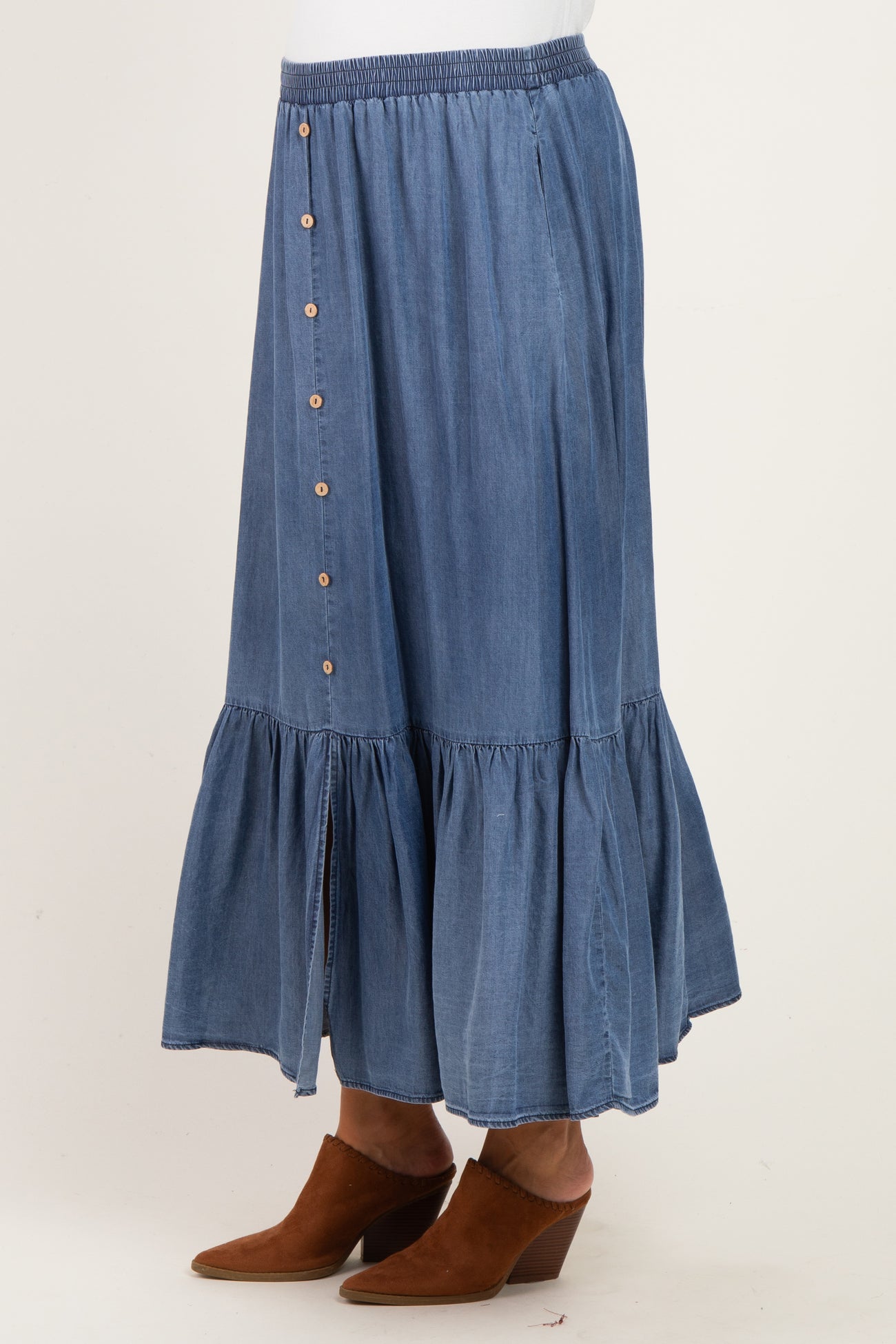 maternity wear denim maxi skirt with button detail and tiered ruffle hem, worn by a model with brown ankle boots
