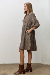 woman wearing a brown floral print midi dress with pockets and long sleeves, styled with brown ankle boots