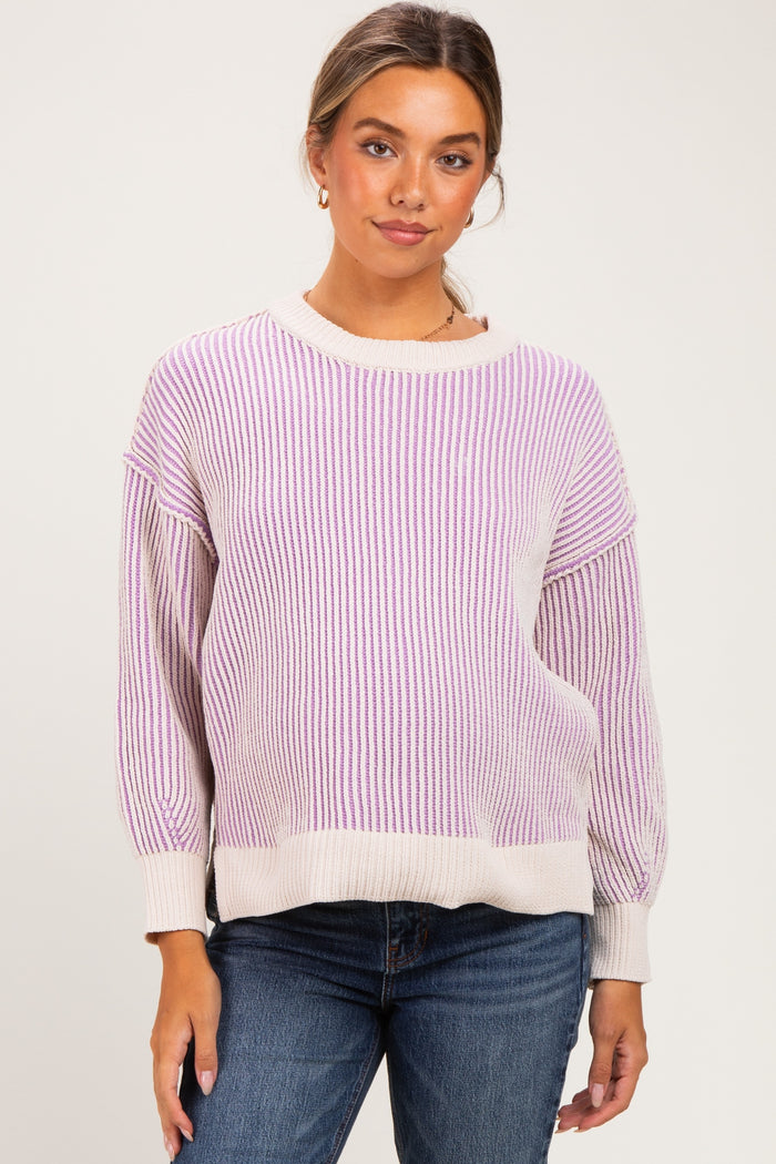 woman wearing a striped light purple and beige maternity sweater with relaxed fit and balloon sleeves