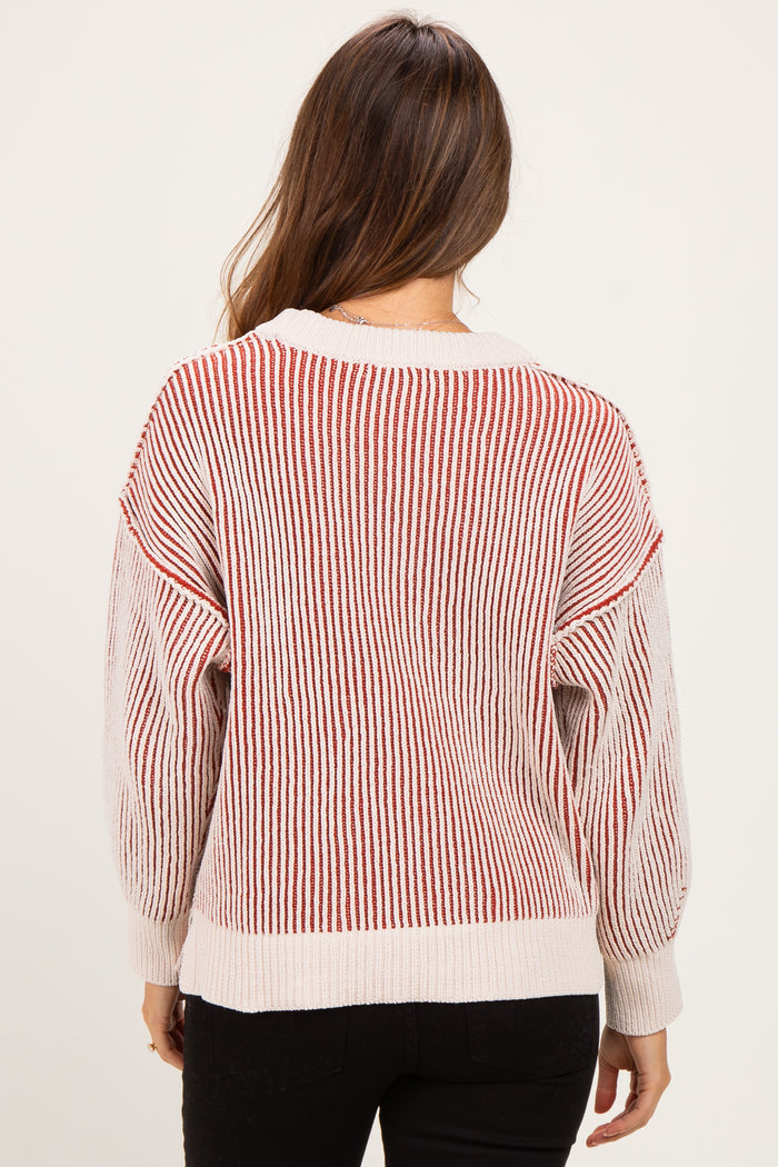 woman wearing a striped red and white oversized maternity sweater with balloon sleeves, seen from the back