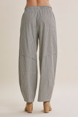 woman wearing black and white striped loose-fitting wide-leg pants, back view
