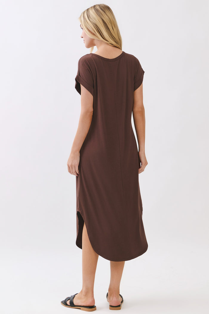 woman wearing a brown short sleeve maxi dress with a side slit and a relaxed fit, seen from the back