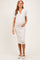 woman wearing a striped white maternity dress with a collar, gently cradling her baby bump