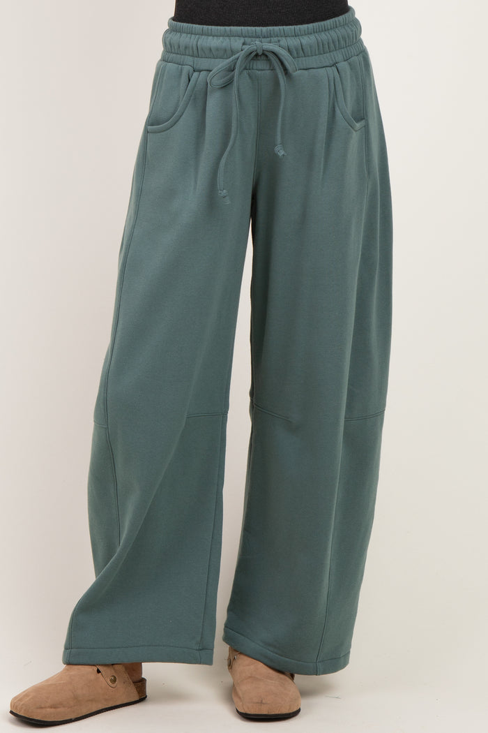 woman wearing oversized teal sweatpants with drawstring waist and side pockets