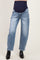 woman wearing light blue maternity jeans with a dark waistband, styled with black ankle boots
