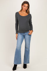 woman wearing a dark gray long sleeve maternity top with scalloped neckline and blue flared maternity jeans