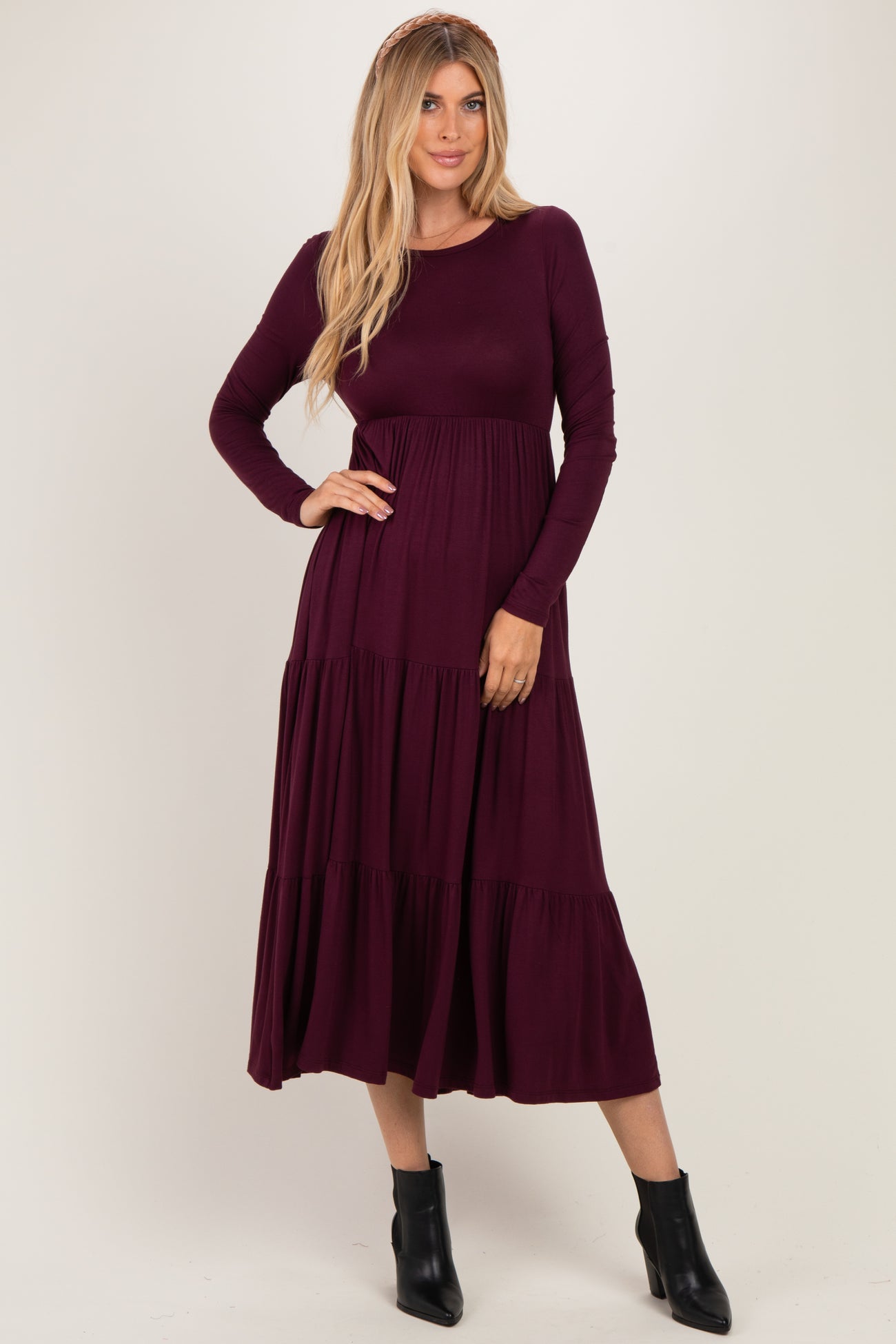 woman wearing a long sleeve burgundy tiered maxi dress and black ankle boots