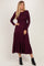 woman wearing a long sleeve burgundy tiered maxi dress and black ankle boots