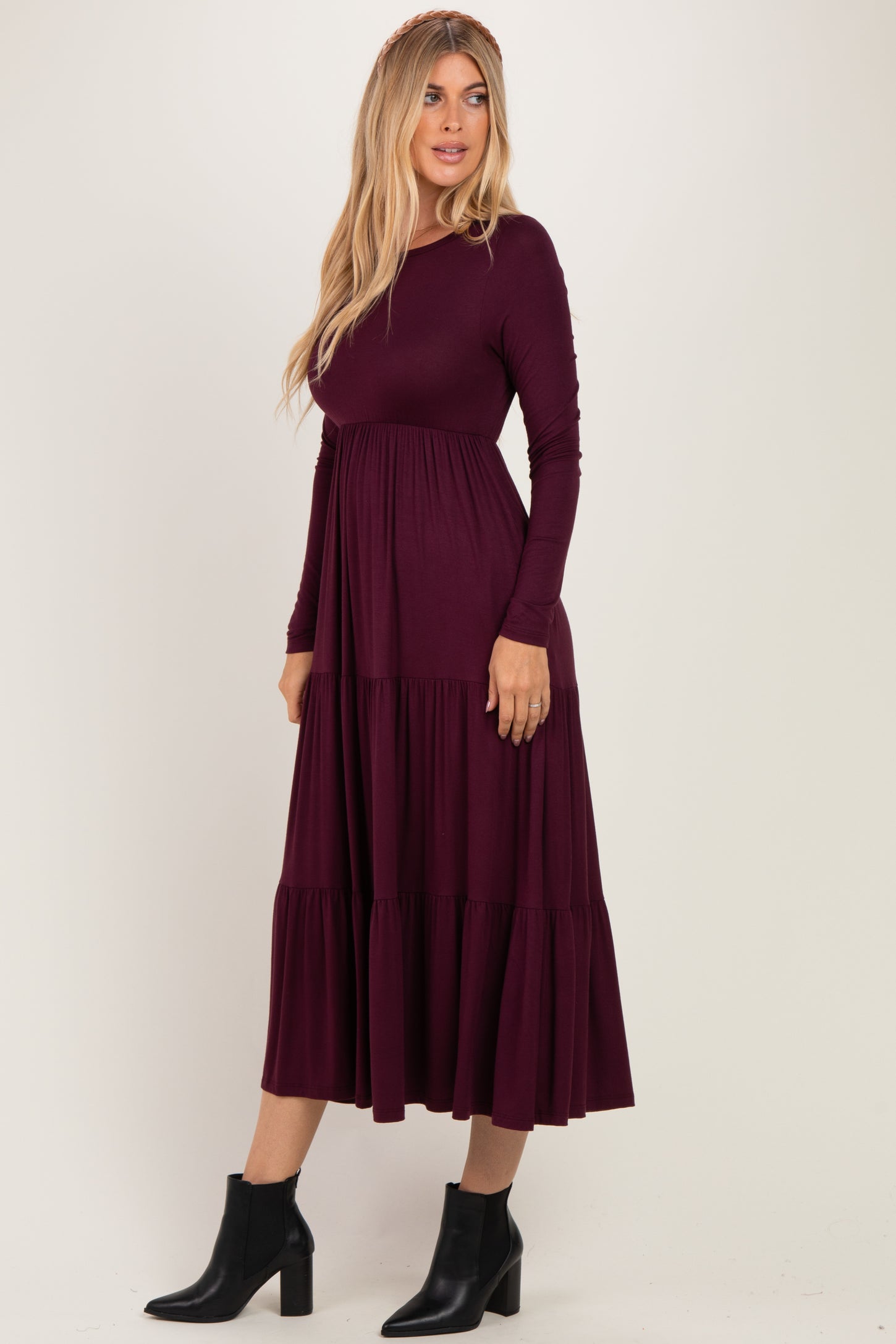 woman wearing a long sleeve burgundy tiered maxi dress and black ankle boots