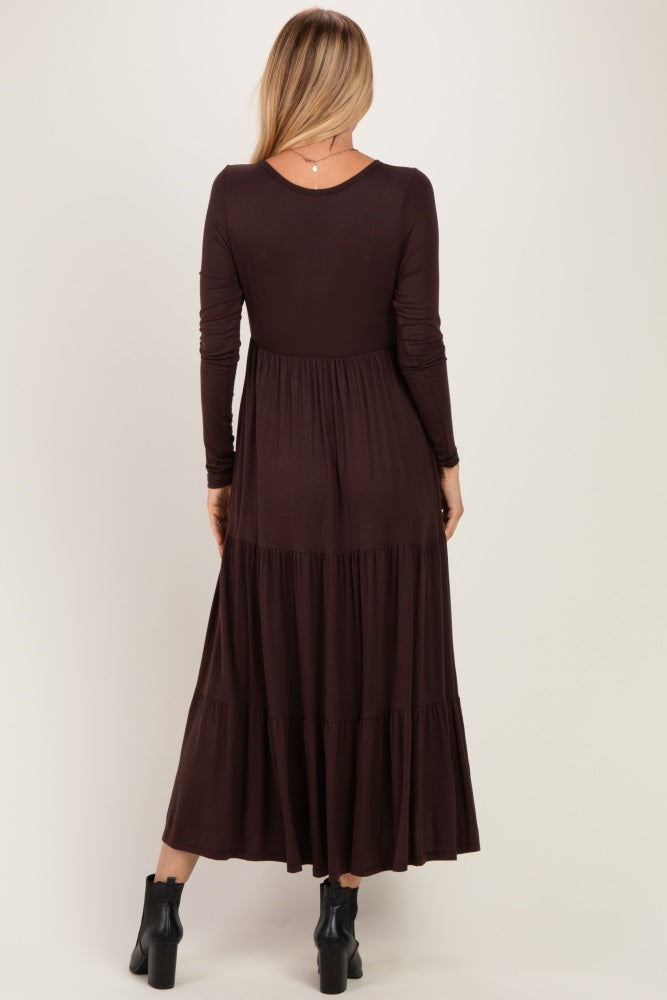 woman wearing a dark chocolate brown long sleeve maxi dress with a tiered skirt, viewed from the back