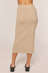 woman wearing a beige ribbed midi skirt, shown from the back, paired with black heeled sandals