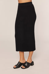woman wearing a black ribbed midi skirt and black slide sandals