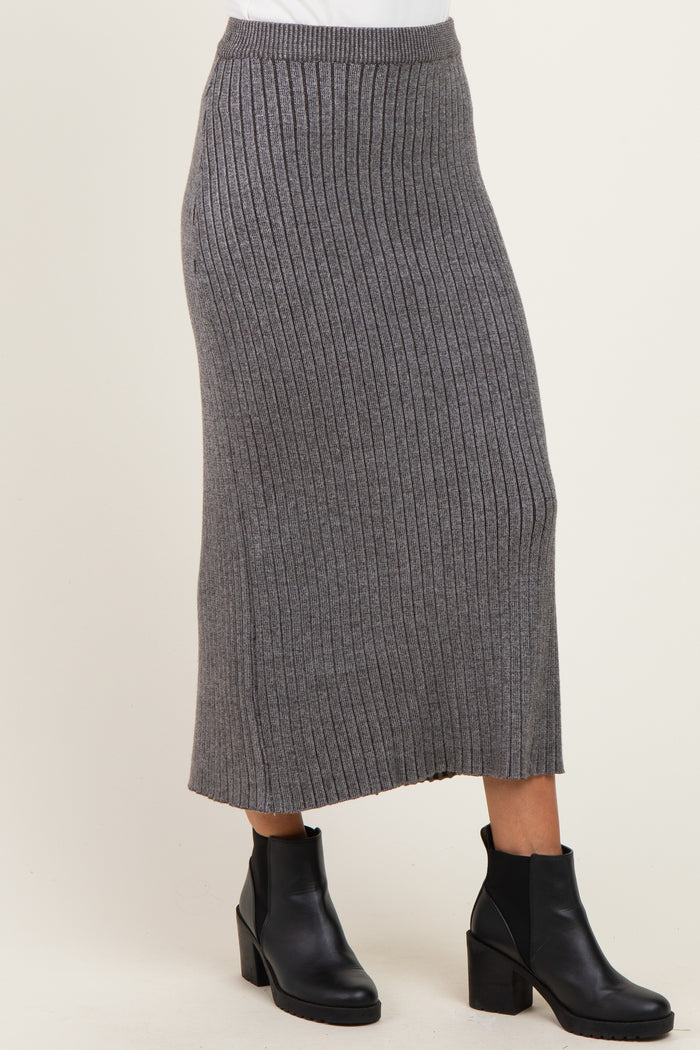woman wearing a gray ribbed midi skirt with a fitted waistband and side slits, paired with black ankle boots