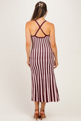 woman wearing a burgundy and cream striped maternity maxi dress with a crisscross back design
