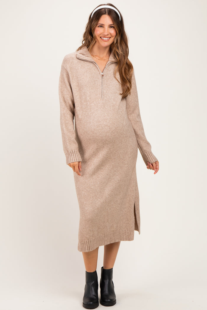 woman wearing a beige zip-up maternity sweater dress with side slits and a baby bump visible