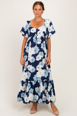woman wearing a floral navy blue maxi dress with short sleeves and a tiered skirt