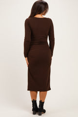 woman wearing a dark brown ribbed maternity dress with a fitted silhouette and long sleeves, seen from the back