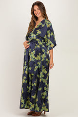 woman wearing a navy floral maternity maxi dress and holding her baby bump
