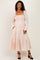 woman wearing a blush pink maternity dress with smocked bodice and long puff sleeves, styled with black heels