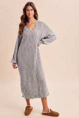 woman wearing a gray ribbed long sleeve sweater dress with a v-neck and relaxed fit