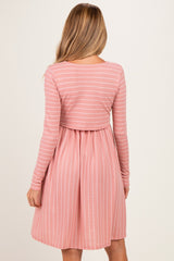 woman wearing a pink and white striped maternity dress with long sleeves and a gathered waist