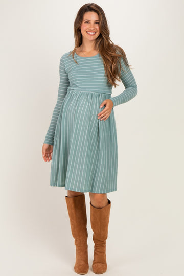 woman wearing a light blue striped long sleeve maternity dress and holding her baby bump