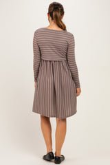 woman wearing a brown striped maternity dress with long sleeves and a fitted bodice, showing a baby bump from the back