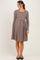 woman wearing a brown and white striped long sleeve maternity dress with a fitted bodice and flared skirt, baby bump visible