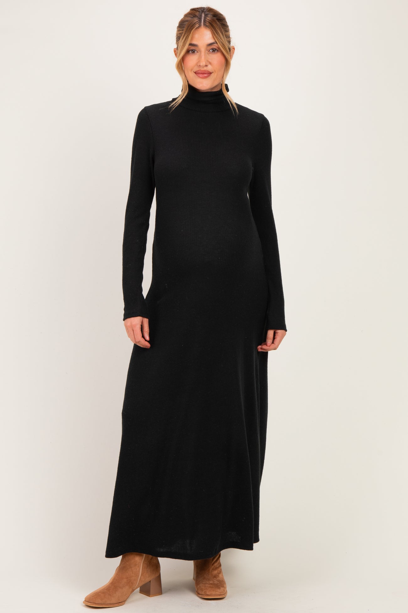 woman wearing a black long sleeve maternity maxi dress with a mock turtleneck and a visible baby bump