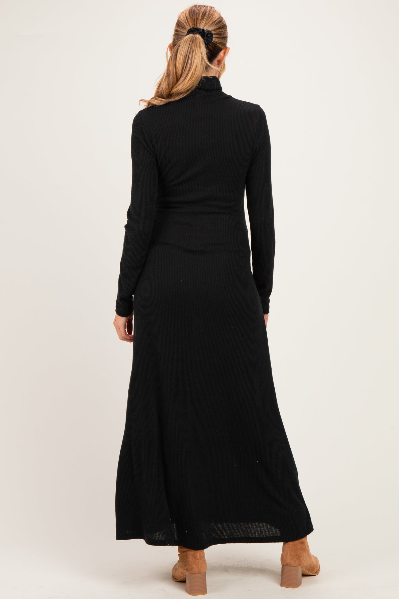woman wearing a black long sleeve ribbed maternity dress, view from the back