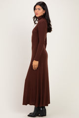 woman wearing a fitted brown ribbed turtleneck maxi dress with long sleeves and a flared skirt