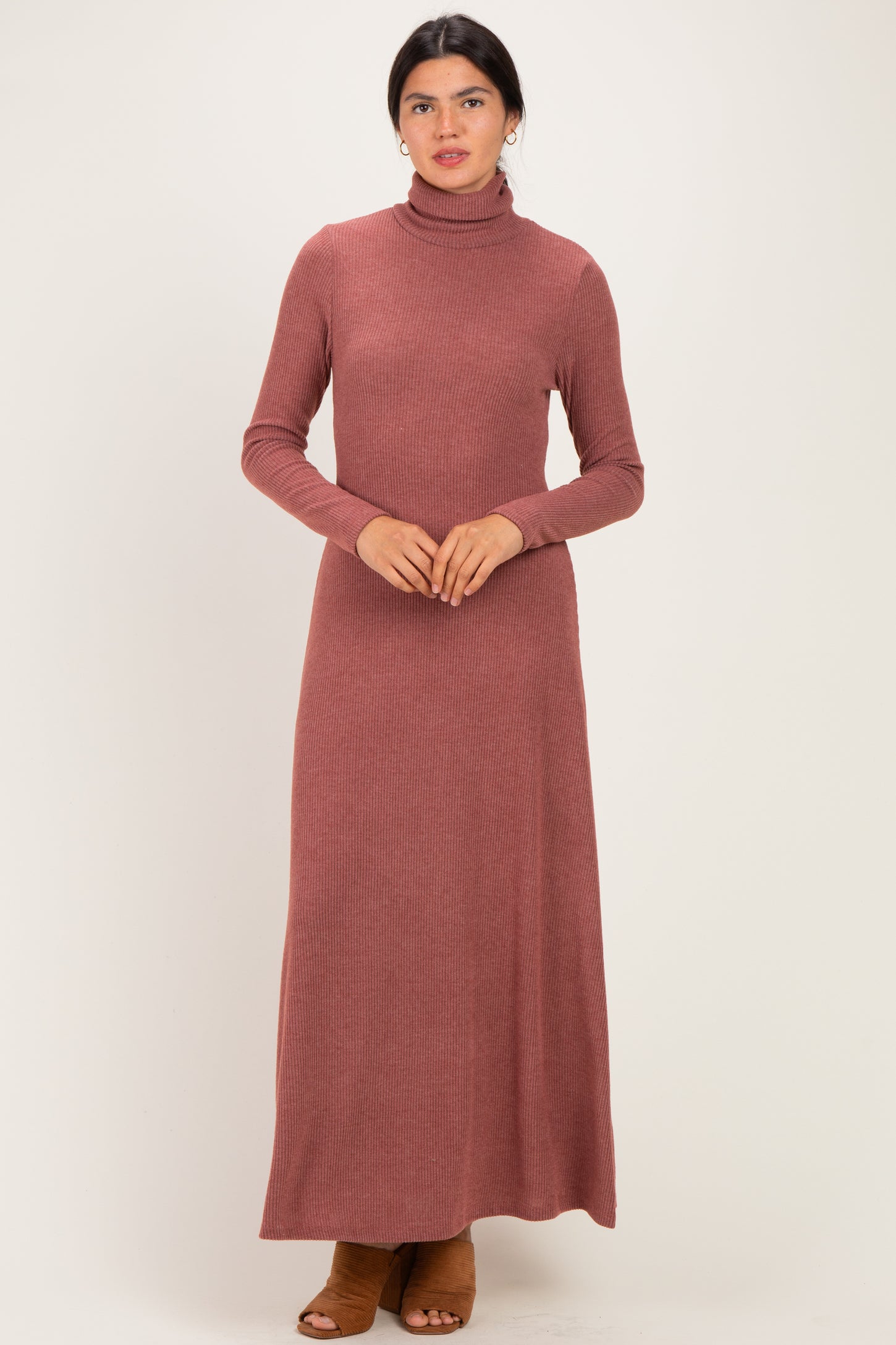 woman wearing a rust long sleeve turtleneck maxi dress with a ribbed texture and brown heeled shoes