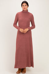 woman wearing a rust long sleeve turtleneck maxi dress with a ribbed texture and brown heeled shoes