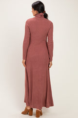woman wearing a rust-colored long sleeve ribbed maxi dress with a turtleneck and open back