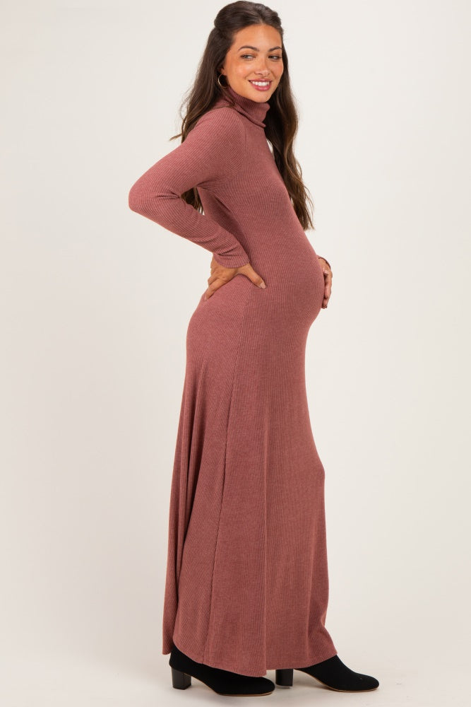 woman wearing a rust long sleeve ribbed maxi dress with a fitted bodice and a flowing skirt, showing her baby bump